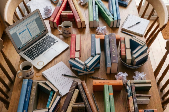 Colorful books arranged in geometric patterns on a wooden dining table